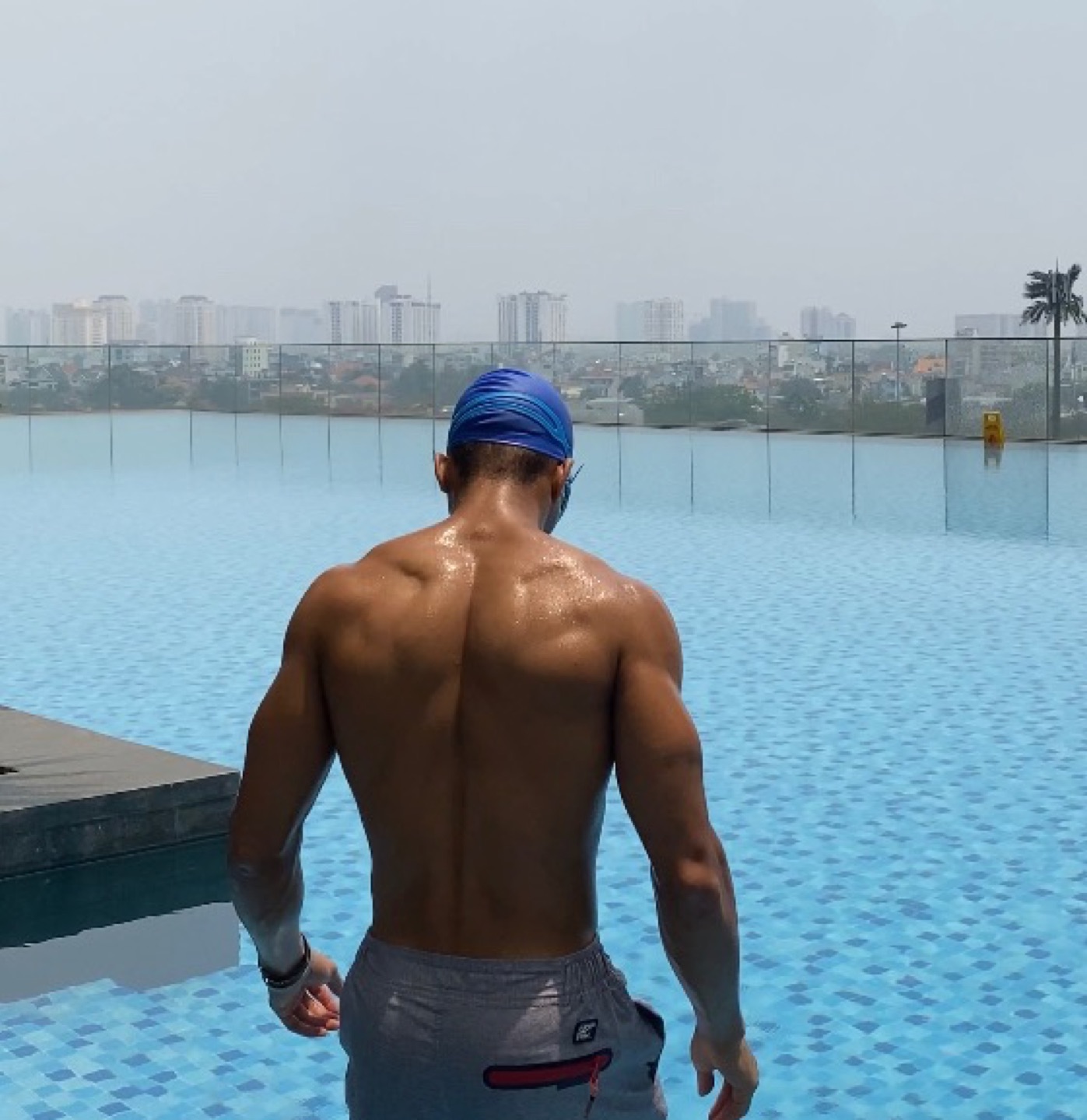 OYOTTA holding a side plank on an outdoor deck with a city skyline